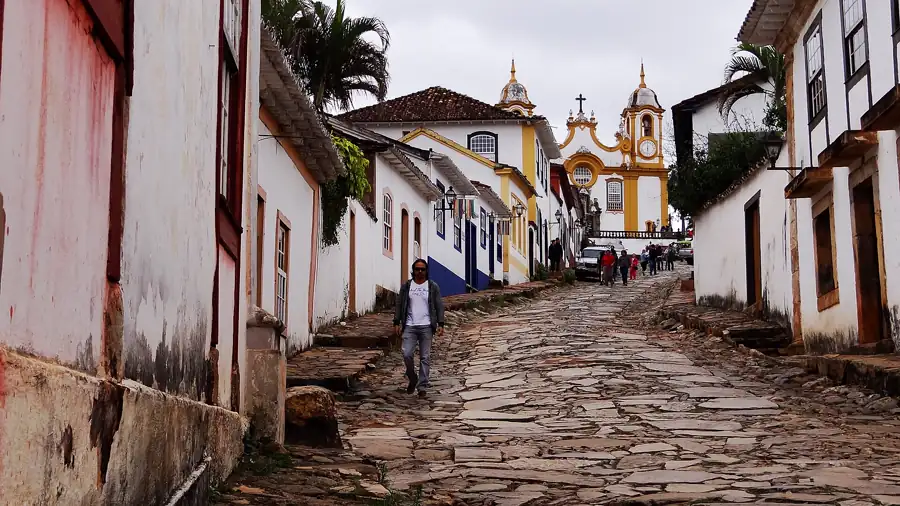 Rua da Igreja Matriz em Tiradentes (MG) — sobrado colonial mineiro com janelas brancas e calçamento de pedra