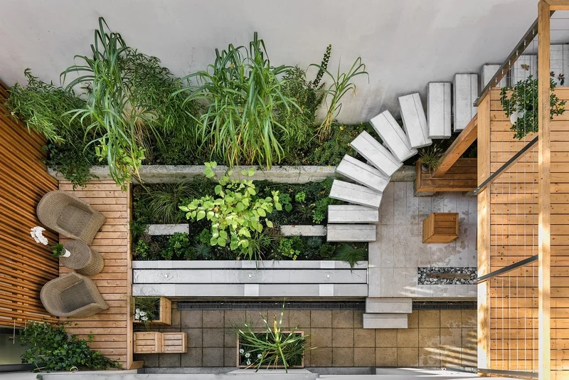 Interior de uma sala de estar contemporânea, ampla e integrada, com grandes janelas de vidro que se abrem para um jardim.