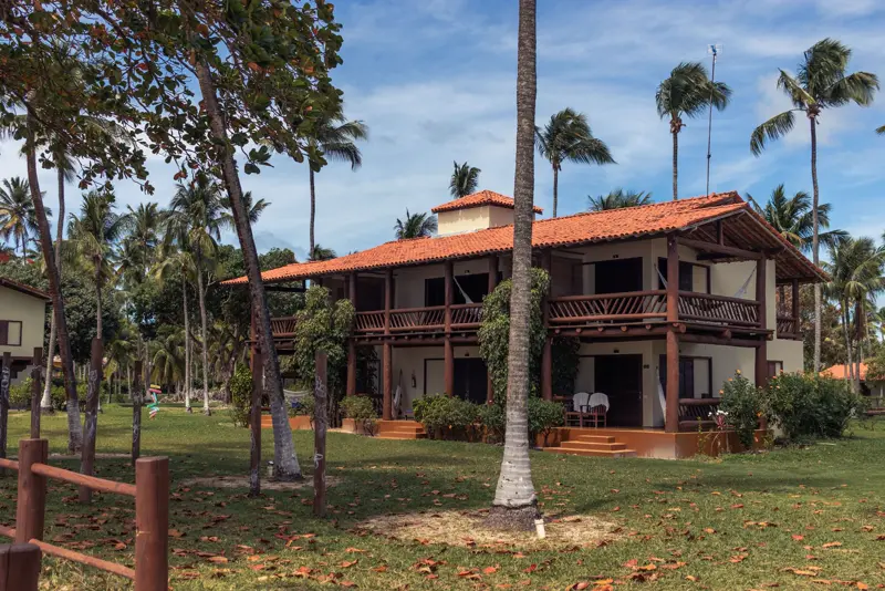 Casa brasileira com telhado cerâmico colonial, madeira, varanda e palmeiras em Morro de São Paulo, Bahia