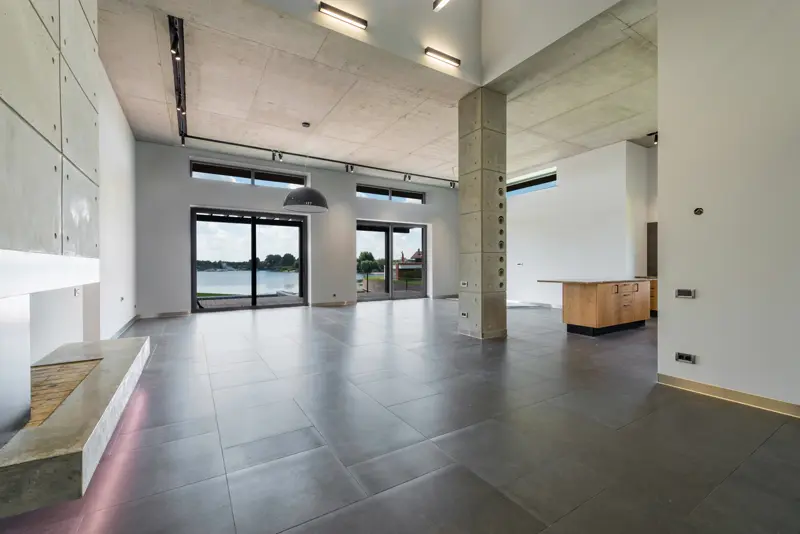 Interior moderno com piso de grandes placas e laje aparente — exemplos de detalhes de acabamentos contemporâneos