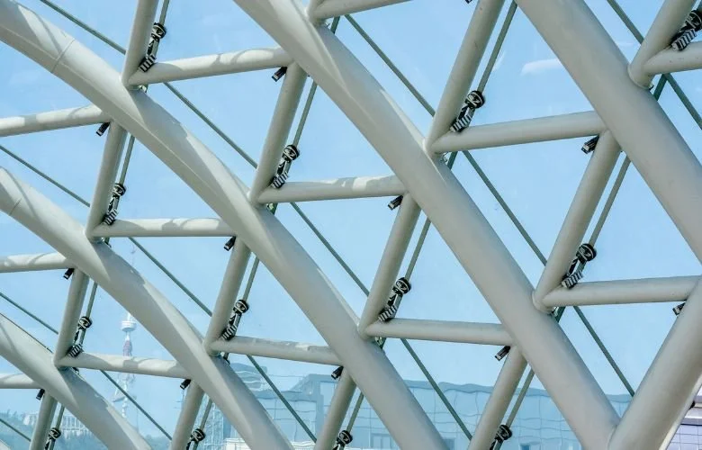 Detalhe de treliça espacial MERO em aço tubular branco — nós metálicos visíveis sob céu azul