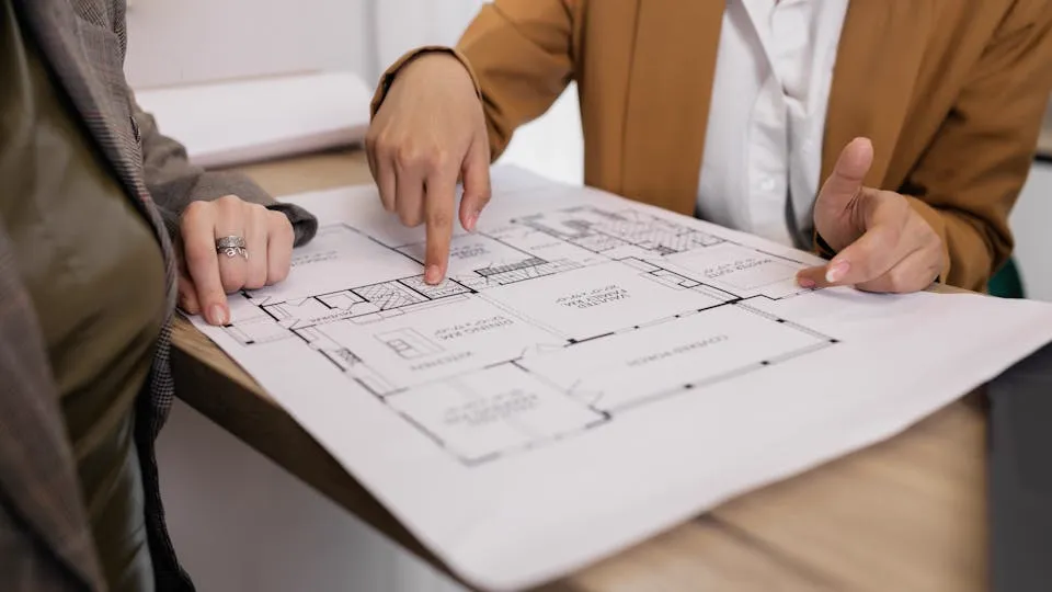 Arquiteto analisando plantas técnicas sobre mesa — responsabilidade técnica