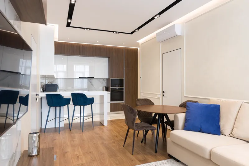Apartamento com portas deslizantes separando sala e quarto em espaço multifuncional integrado